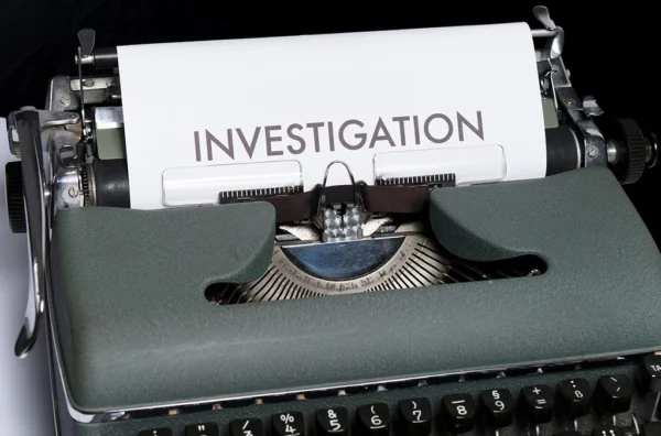 Picture of a typewriter with a paper were it stands Investigation in big letters.