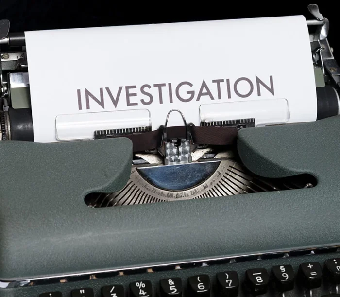 Picture of a typewriter with a paper were it stands Investigation in big letters.