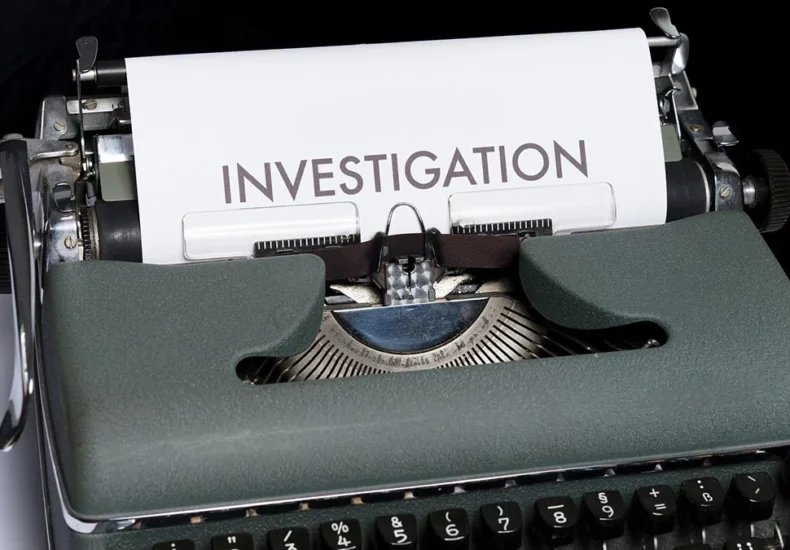 Picture of a typewriter with a paper were it stands Investigation in big letters.