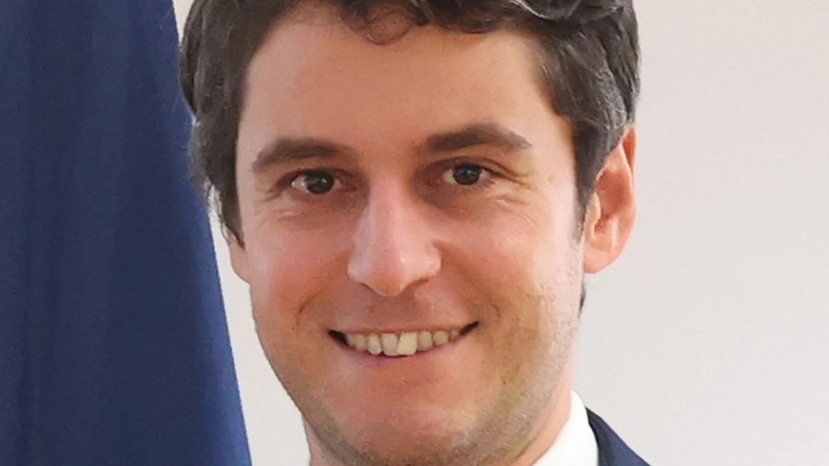 Picture of Gabriel Attal (headshot) - smiling - in a white shirt and suite.